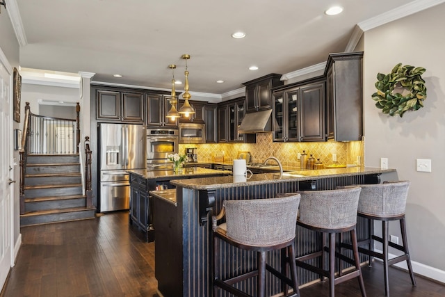 kitchen featuring stainless steel appliances, dark hardwood / wood-style floors, a kitchen breakfast bar, stone counters, and pendant lighting