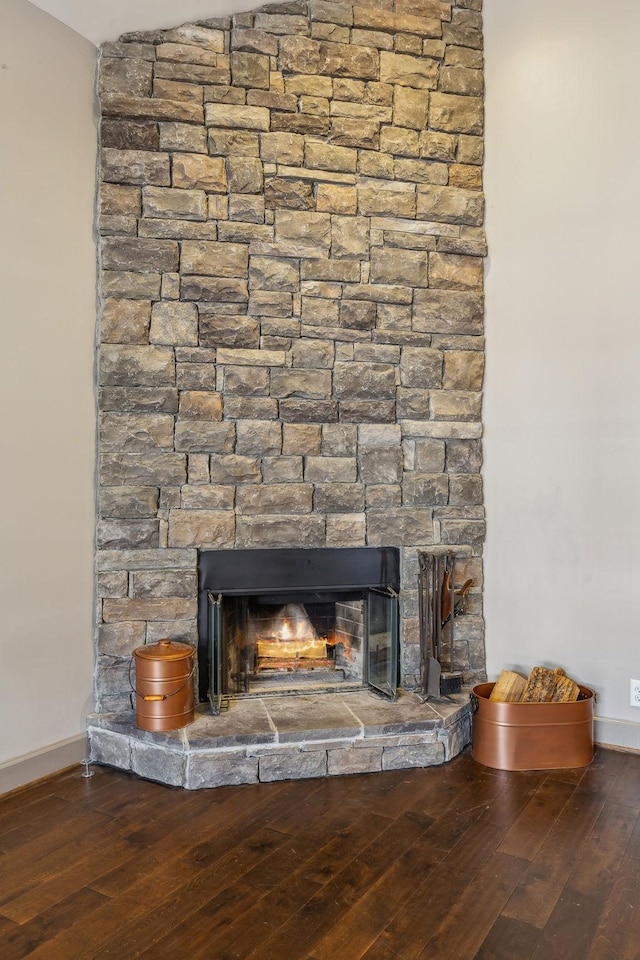 details featuring hardwood / wood-style flooring and a stone fireplace