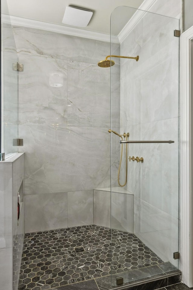 bathroom featuring a shower with door and crown molding