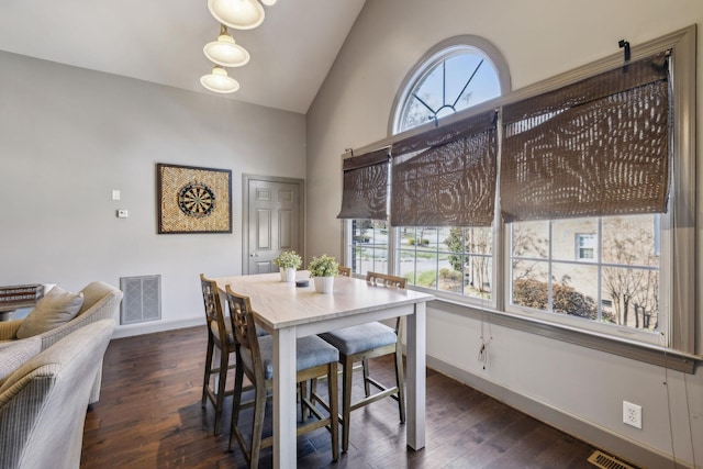 dining area with plenty of natural light, dark hardwood / wood-style flooring, and lofted ceiling