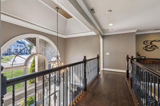 hall with dark hardwood / wood-style flooring, ornamental molding, and an inviting chandelier