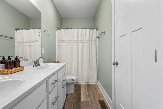 bathroom with hardwood / wood-style flooring, toilet, and vanity