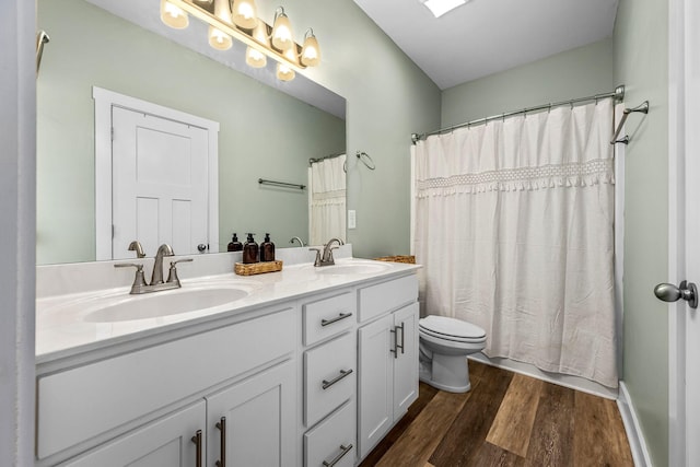 full bathroom with hardwood / wood-style floors, toilet, vanity, and shower / bath combo