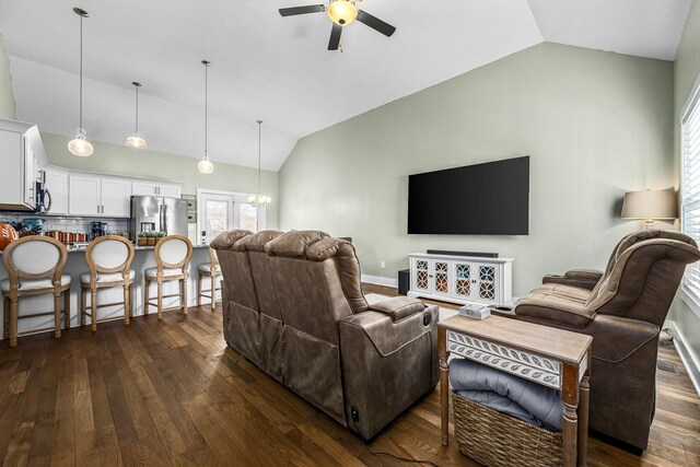 living room with dark hardwood / wood-style flooring, lofted ceiling, and ceiling fan with notable chandelier