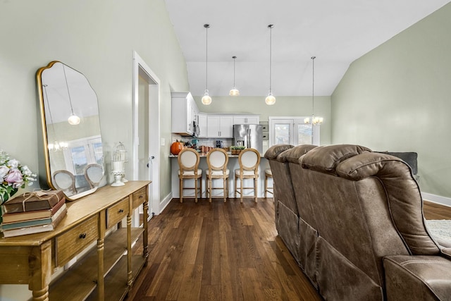 living room featuring vaulted ceiling, a chandelier, and dark hardwood / wood-style floors