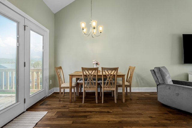 dining area with vaulted ceiling, dark hardwood / wood-style flooring, and an inviting chandelier