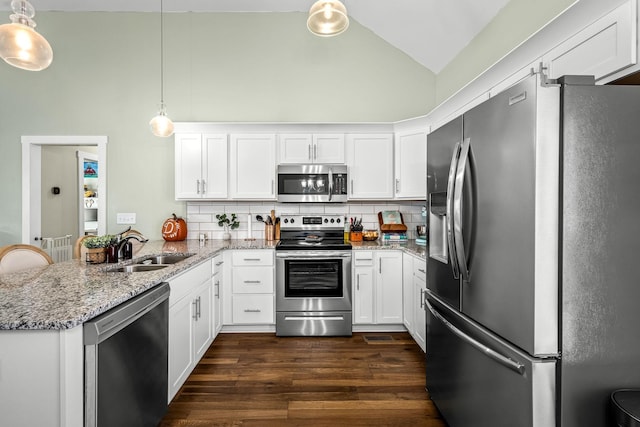 kitchen featuring kitchen peninsula, stainless steel appliances, backsplash, hanging light fixtures, and sink