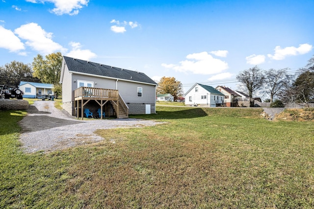 rear view of house featuring a deck and a yard