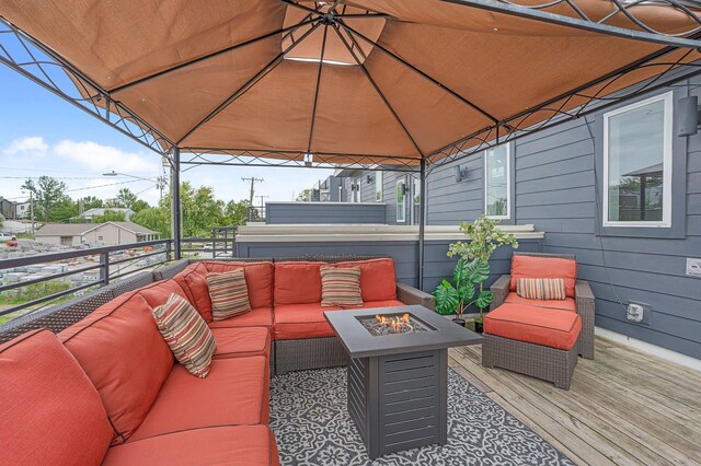 wooden deck featuring an outdoor living space with a fire pit and a gazebo