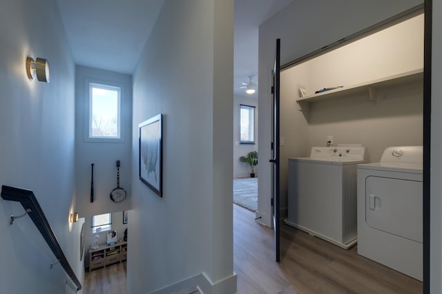 laundry area featuring ceiling fan, washer and dryer, and light hardwood / wood-style floors