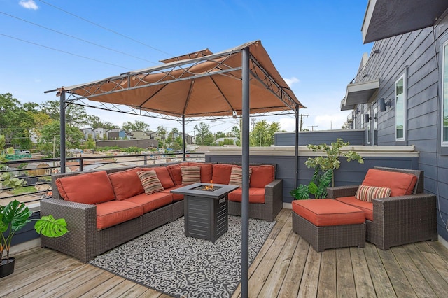 wooden terrace with an outdoor living space with a fire pit and a gazebo