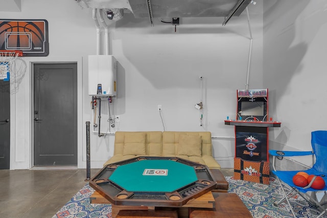 playroom featuring water heater and concrete flooring