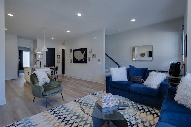 living room with light wood-type flooring and sink