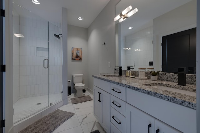 bathroom with toilet, a shower with shower door, and vanity