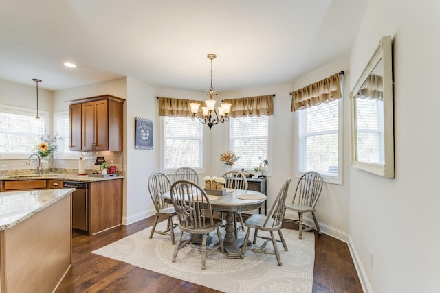 dining space featuring dark wood-type flooring, sink, and a chandelier