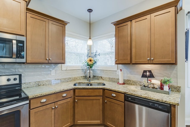 kitchen featuring appliances with stainless steel finishes, backsplash, hanging light fixtures, and sink