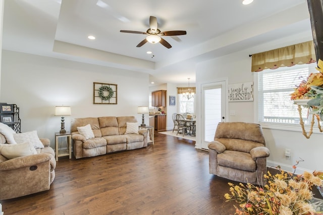 living room featuring ceiling fan, a wealth of natural light, dark hardwood / wood-style floors, and a raised ceiling