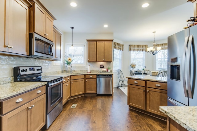 kitchen featuring decorative light fixtures, backsplash, dark hardwood / wood-style floors, and stainless steel appliances