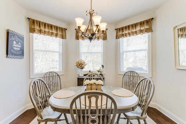 dining space with dark hardwood / wood-style floors and an inviting chandelier