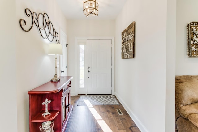 foyer featuring dark hardwood / wood-style flooring and a chandelier