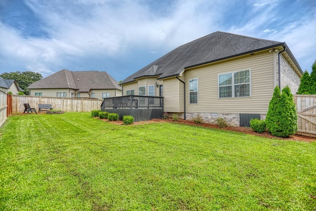 back of house featuring a wooden deck and a lawn