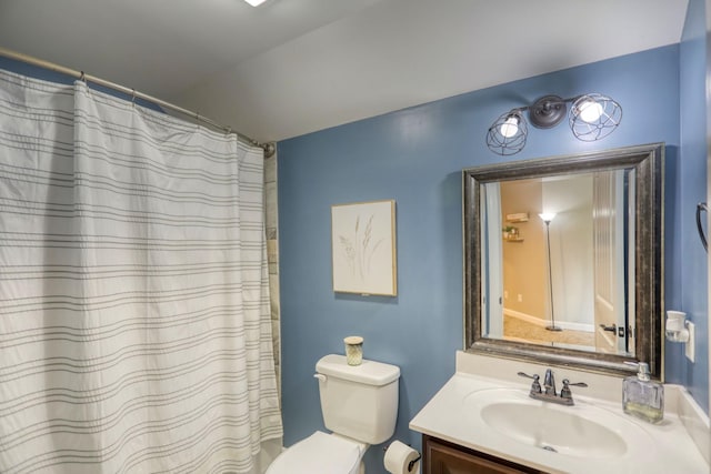 bathroom featuring toilet, vanity, and a shower with curtain