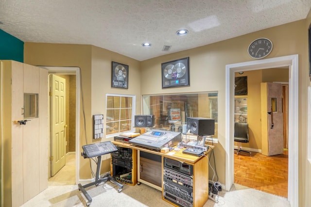 home office with a textured ceiling and light parquet flooring