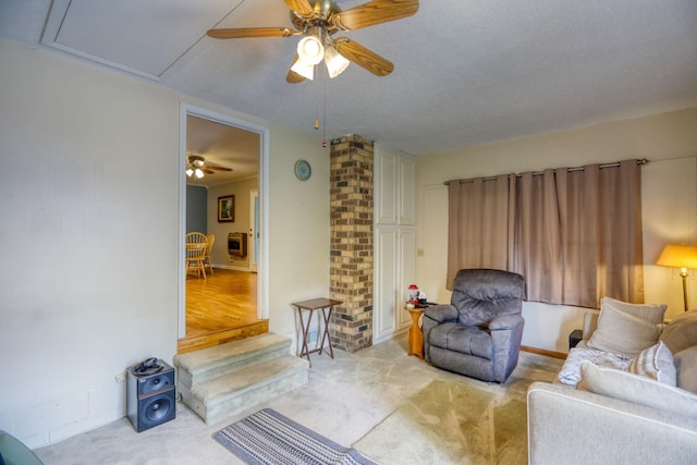 carpeted living room with ceiling fan and a textured ceiling