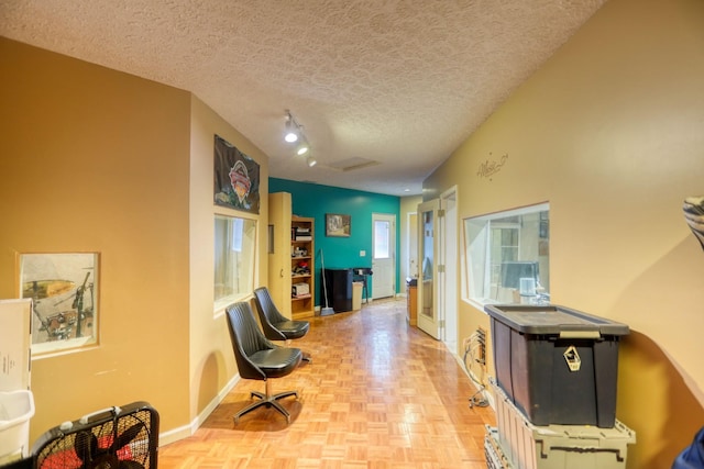 interior space featuring a textured ceiling and light parquet flooring