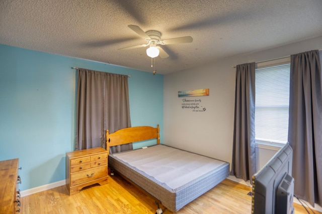 bedroom featuring a textured ceiling, ceiling fan, and hardwood / wood-style flooring