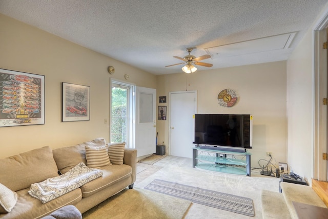 living room with a textured ceiling, ceiling fan, and light carpet