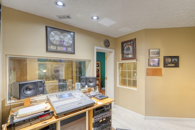 home office featuring carpet floors and a textured ceiling