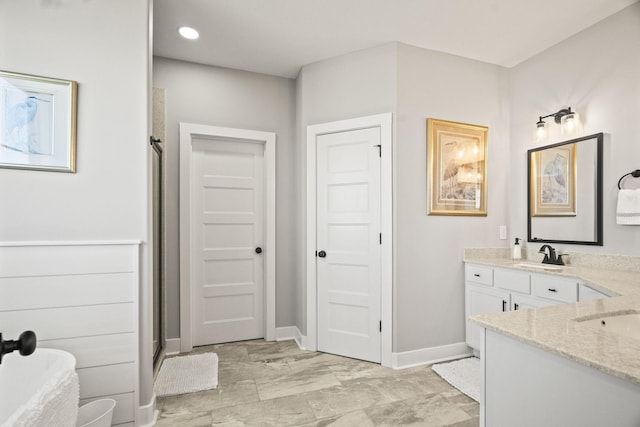 bathroom with a shower with shower door and vanity