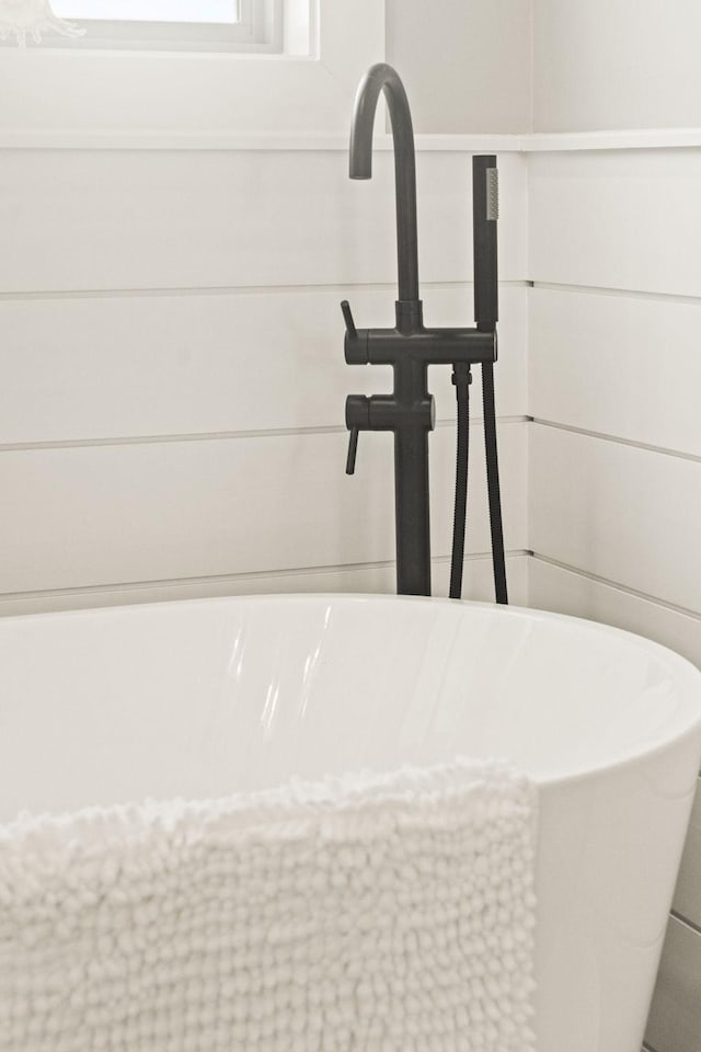 details featuring sink and a tub to relax in