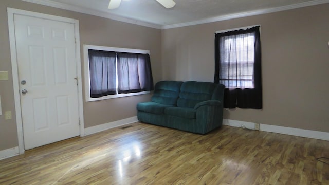 living area with crown molding and hardwood / wood-style flooring