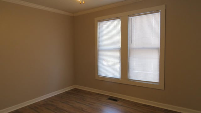 unfurnished room featuring dark hardwood / wood-style flooring and crown molding