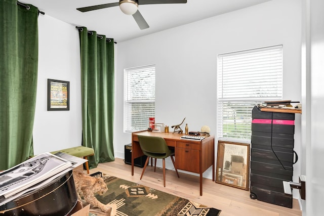 office with light wood-type flooring and ceiling fan