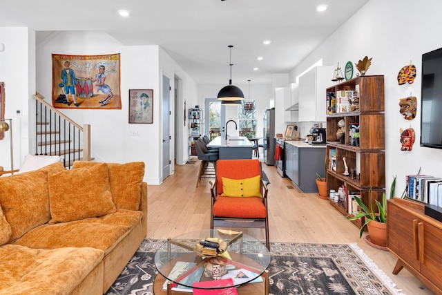 living room featuring sink and light hardwood / wood-style flooring