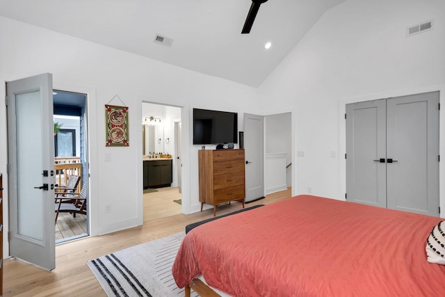 bedroom with ceiling fan, ensuite bath, a closet, lofted ceiling, and light hardwood / wood-style flooring