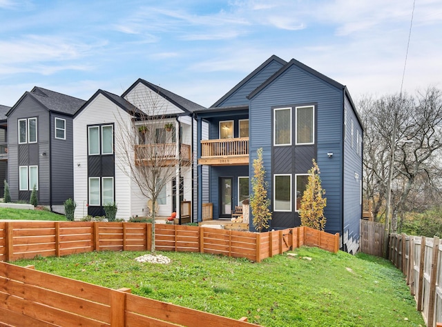 view of front of home featuring a front lawn and a balcony