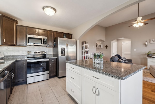 kitchen featuring tasteful backsplash, white cabinetry, dark brown cabinetry, and stainless steel appliances