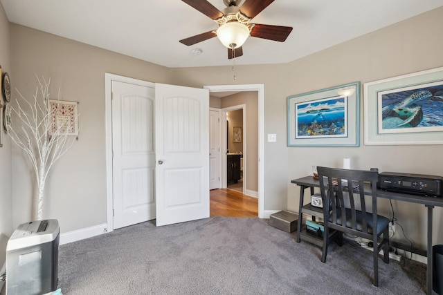 office featuring ceiling fan and dark carpet