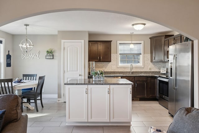 kitchen featuring sink, hanging light fixtures, appliances with stainless steel finishes, and tasteful backsplash