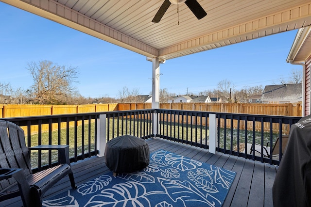 wooden terrace with ceiling fan and a yard