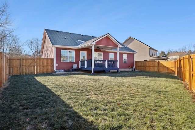 back of house with a deck and a lawn