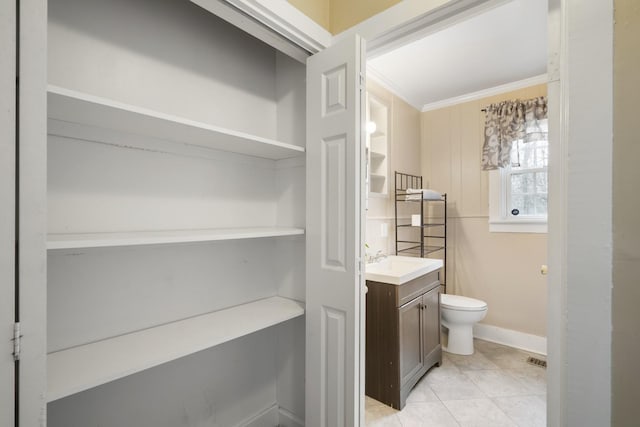 bathroom featuring vanity, tile patterned floors, ornamental molding, and toilet