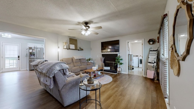 living room with ceiling fan, wood-type flooring, and a textured ceiling