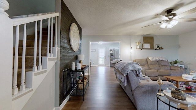 living room featuring a textured ceiling, ceiling fan, and dark hardwood / wood-style flooring