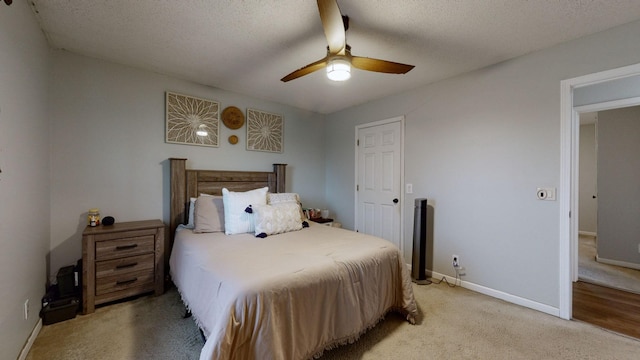 carpeted bedroom with ceiling fan and a textured ceiling