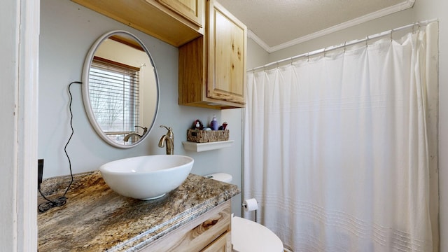 bathroom featuring toilet, vanity, ornamental molding, and a textured ceiling